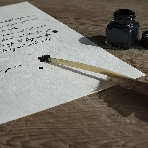 A sheet of paper with quill pen and ink